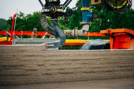 Aus dem Rohrarm wird Beton Schicht für Schicht zu einer Wand geformt
