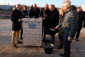 Die Verantwortlichen starten mit einer Grundsteinlegung das Projekt
